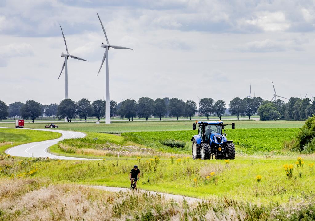 landschap met tractor, windturbines en fietser